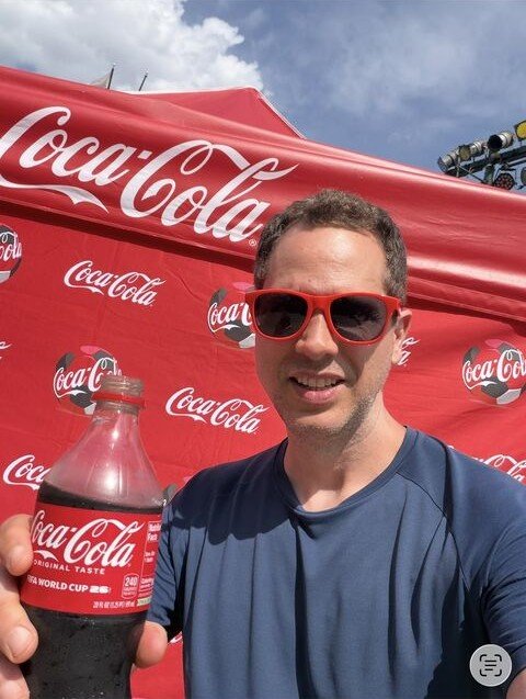 Denis Araújo no SeaWorld Orlando, com os óculos vermelhos da ativação da Coca-Cola